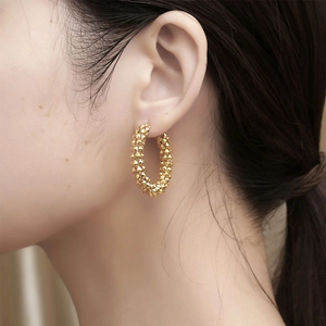 Retro gold hoop earrings with textured stud design for women shown on a model