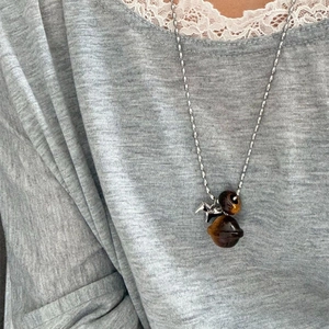 Tiger eye stone pony pendant necklace on grey knitwear for a vintage style