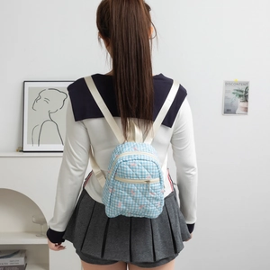 Detail of pink bow embroidery on blue and white gingham school backpack for students