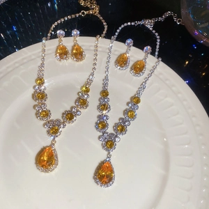 Macro view of teardrop zircon jewelry sets with necklaces and earrings in gold and silver