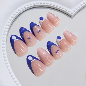 Faux ongles French bleu foncé élégants avec perles et fleurs sur un socle miroir coeur