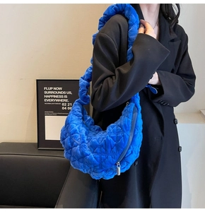 Detail of blue quilted velvet cloud bag shoulder carry on black blazer outfit