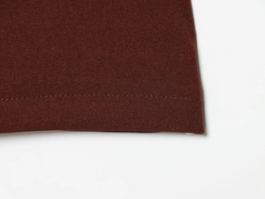 Detailed view of brown fabric stitching and fine texture on wide leg pants set
