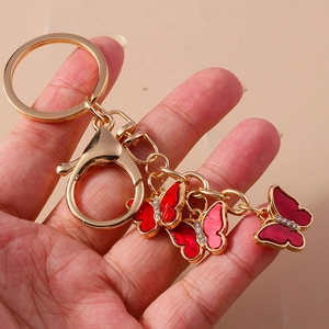 Detail of pink butterfly keychain with golden ring and small rhinestones on wings