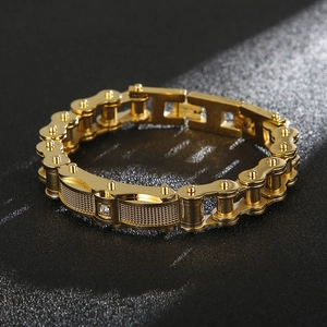 Vista macro del bracciale da uomo a catena in acciaio dorato con dettaglio a rete e diamante