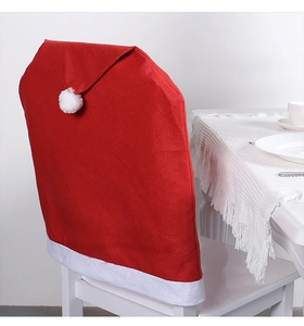 Detail of red Santa hat chair cover with white plush pom-pom and soft felt fabric texture