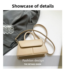 Detail of beige leather crossbody bag with light gold hardware and textured handle