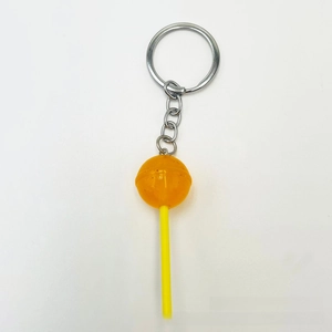 Close-up of a yellow translucent acrylic lollipop keychain with silver metal ring