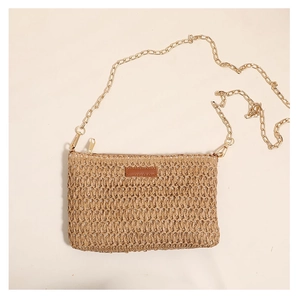 Detail of the natural straw woven texture and khaki color of this square crossbody bag