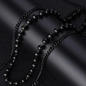 Detail of multi-layer black stainless steel beaded and flat chains on a display stand