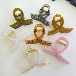 Vue détaillée de pinces à cheveux au design croisé en sept couleurs vives assorties