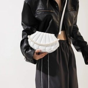 White shell crossbody bag with pearl chain detail worn with black leather jacket