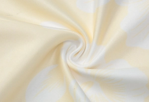 Close-up of yellow floral fabric showing detailed twill texture and soft petal print