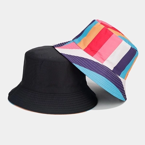 Detail showing reversible bucket hat with black solid side and vibrant rainbow stripe pattern