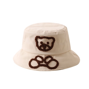 Gros plan sur la broderie ours en peluche sur le chapeau de soleil beige pour bébé