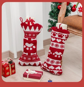 Detail of red and white knitted dog bone and traditional stockings by a Christmas tree