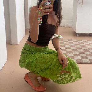 Detail view of vibrant green lace maxi skirt with intricate floral mesh patterns
