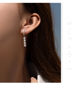 Close-up of S925 sterling silver flower earrings with crystals on a female model