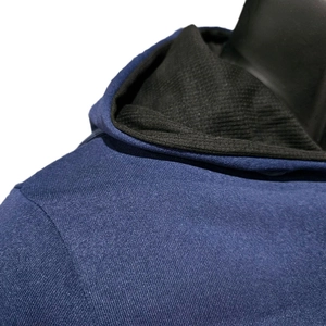 Détail du sweat à capuche bleu marine avec doublure côtelée noire et texture tricot