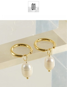 Dettaglio di orecchini in titanio placcato oro 18 carats con perle bianche