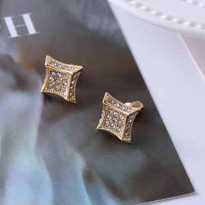 Macro shot of gold-plated rhombus stud earrings with micro-paved crystal diamonds