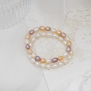 Detailed view of double-layer natural pearl bracelet in white pink and orange hues