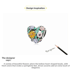 Macro shot of silver heart charm featuring colorful enamel flowers and zircon stones