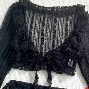 Detail of black floral lace bikini cover-up with ruffled V-neck and front tie closure