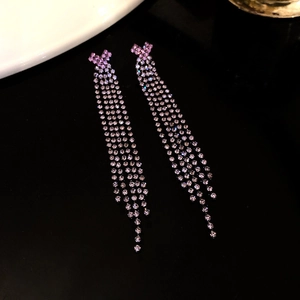 Macro shot of long tassels on rhinestone earrings with purple pink gradient effect