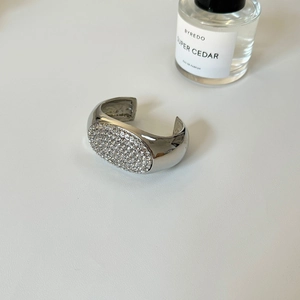 Detailansicht der silbernen Manschettenknöpfe mit Zirkonia-Besatz auf Lederhintergrund