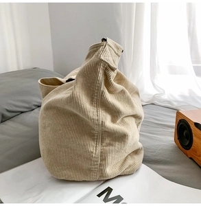 Detailed close-up of beige corduroy tote bag on a magazine in a cozy setting