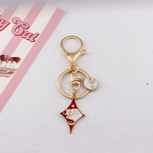 Detail of golden metal keychain with diamond cat pendant and moon star charm charms