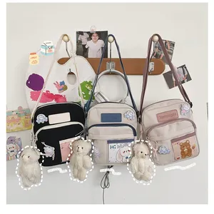 Détail du sac bandoulière en toile avec poches avant et breloque ours en peluche