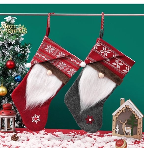 Detail of red and grey gnome Christmas stockings with white snowflake knit patterns