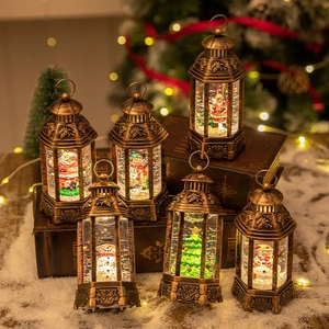Vintage Christmas lanterns with LED glowing snow globes and Santa figurines on books