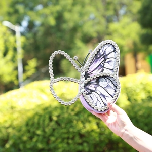 Detailed close-up of butterfly evening bag with purple wings and glittering rhinestones