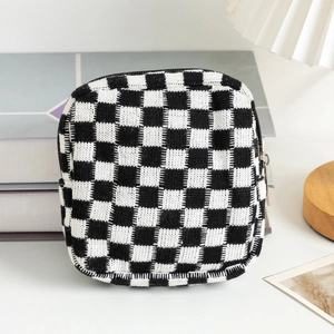 Macro view of checkered knit cosmetic pouch with soft texture and silver zipper detail