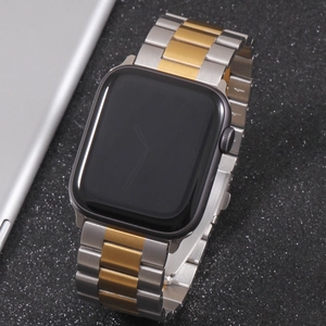 Macro detail of silver and gold two-tone stainless steel three-bead link watch band