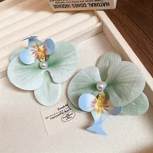 Elegant gradient orchid hair clip with pearl center on a minimalist jewelry tray