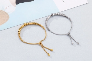 Detail of adjustable metal beaded bracelets in gold and silver with drawstring closure