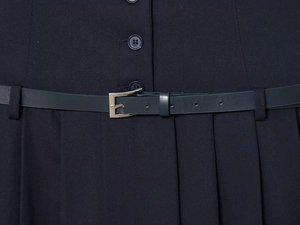 Detail der dunkelblauen Kleid-Taille mit Knopfleiste, Ledergürtel und plissiertem Stoff