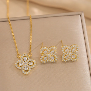 Gold flower jewelry set with white zircon necklace and stud earrings on silk background