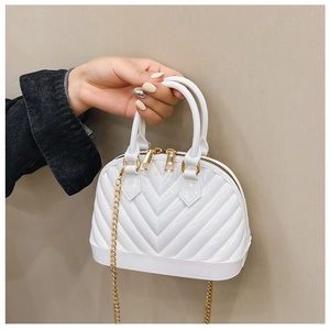 Detail of white jelly shell bag featuring V-shaped texture and gold chain strap