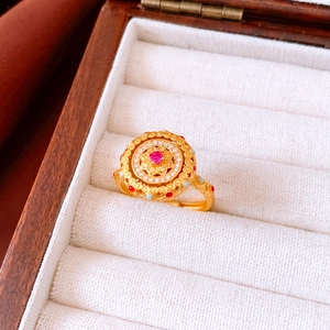 Vue détaillée de la bague vintage en or avec zircon rouge et accents de diamants