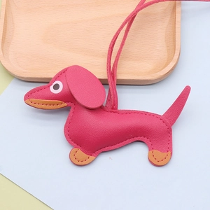 Detail of pink faux leather dachshund pendant with orange stitching and leather lanyard