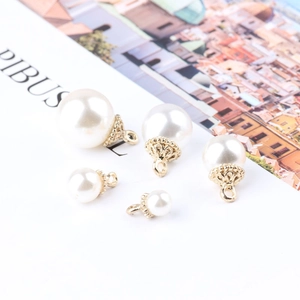 Macro shot of five gold-plated pearl pendants in various sizes for DIY jewelry making