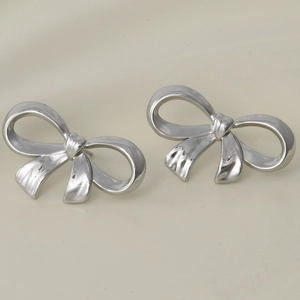 Détail macro de boucles d'oreilles nœuds en argent poli et acier inoxydable 304 brillant