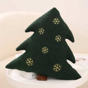 Detailed view of green fleece Christmas tree pillow with golden snowflake embroidery