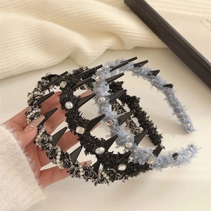 Three elegant woven headbands with pearls and rhinestones held in hand for hair styling