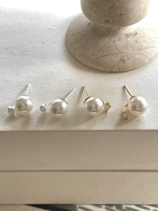 Detailed view of pearl and zircon stud earrings in silver and gold plating